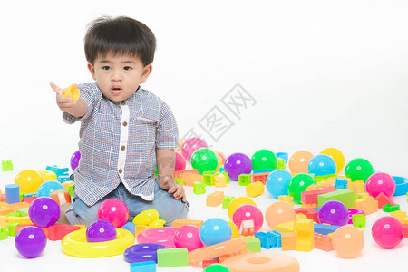 年轻的亚裔小孩在多种彩玩具中玩耍图片