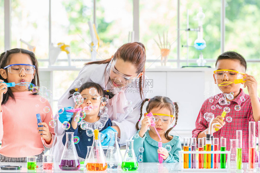 科学老师和亚洲学生在实验室房间里吹泡泡彩色试管和显微镜在实验室房间的桌子上在实验室房间图片