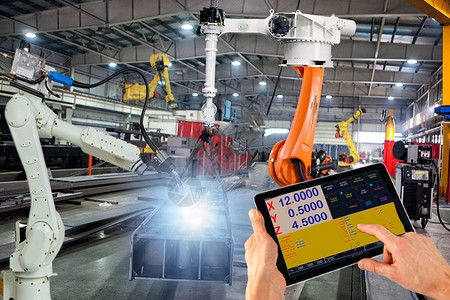 电子电器工程师用监控系统软件对智能工厂工业中的焊接机器人自动臂机进行检查和控制数字制造业务背景