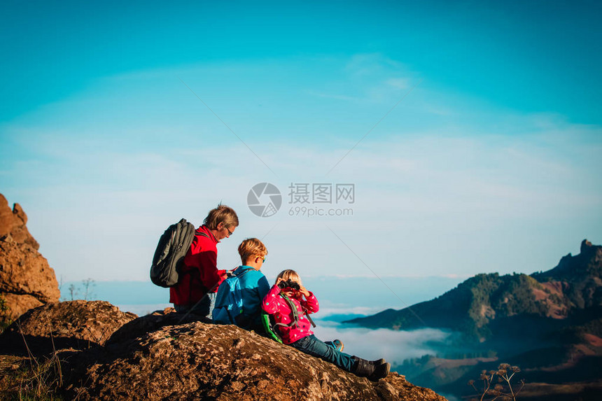 快乐的父亲和孩子们在山上徒步旅行图片