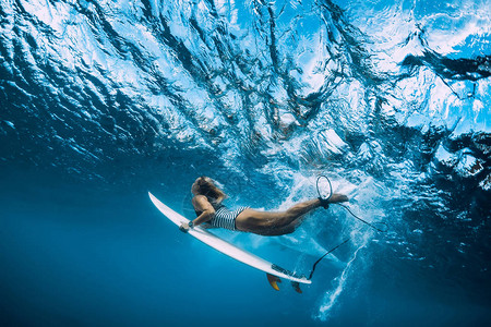 冲浪的女人带着海浪潜入水下高清图片