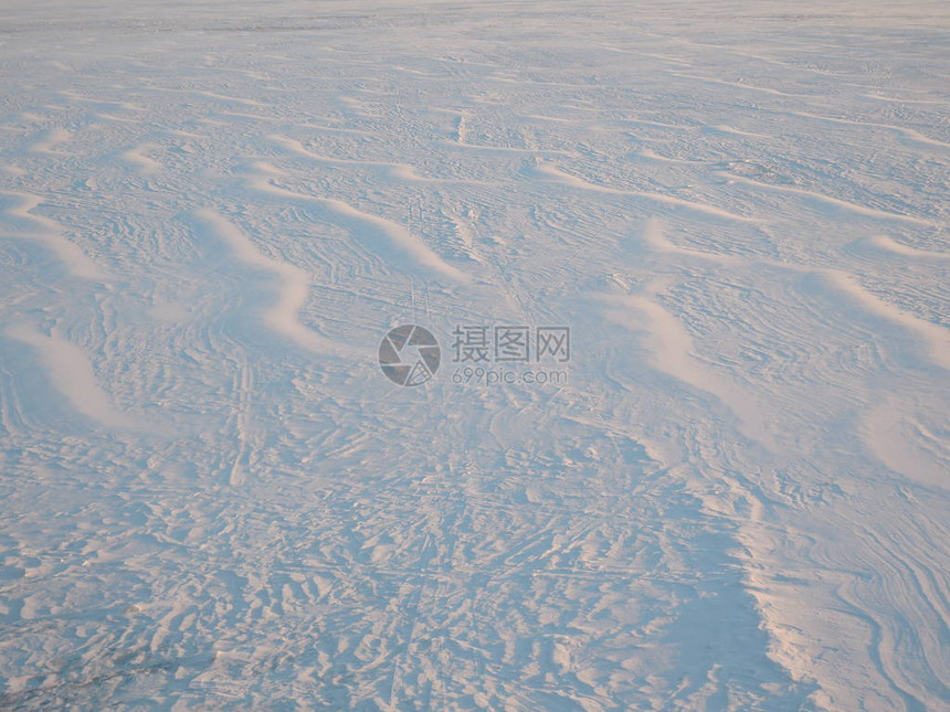 日出时由风形成的雪面图片