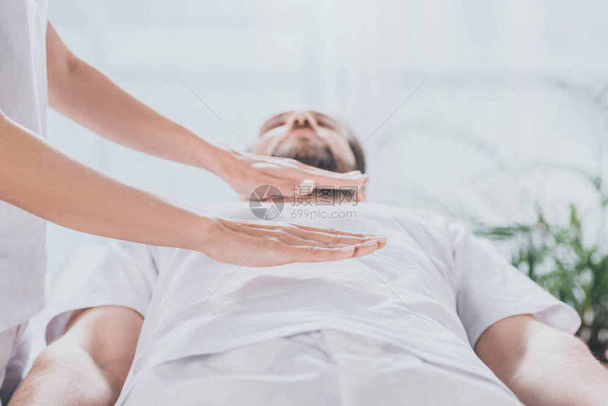 一个长胡子的男人在胃上接受灵气治疗图片