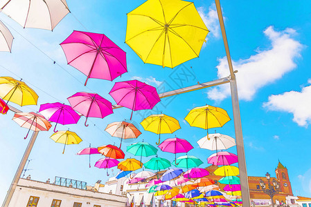 蓝色天空上挂着色彩多的雨伞水彩花图片