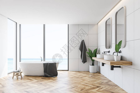 现代洗手间内部有白色瓷砖墙木地板大窗户白色浴缸和两面图片