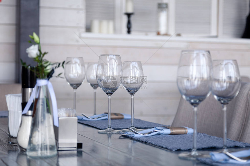餐厅内部现代环境酒杯和水杯纺织餐巾纸上的叉子和刀子在老式灰色木桌上排成一排概念宴会生日会图片