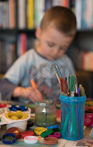 小caucasian男孩坐在家里的桌子上背景图片