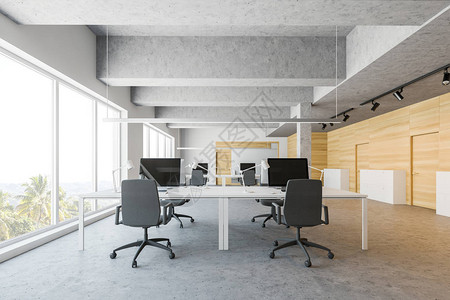 开放空间办公室的内部有白色和木墙混凝土地板和一排大型白色电脑桌图片