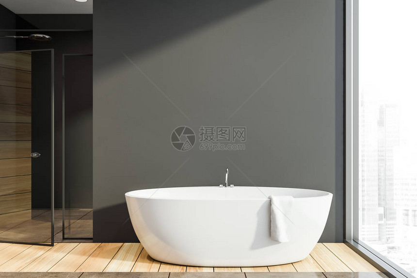 现代卫生间内部有深灰墙木地板舒适的白色浴缸图片