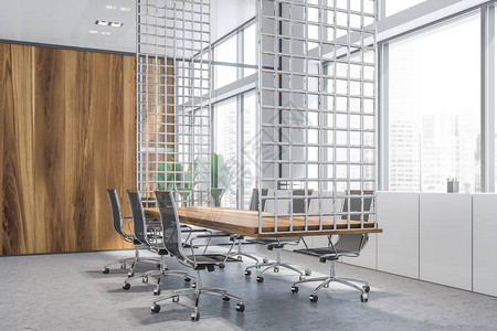 现代会议室的角落有白色和木墙混凝土地板大窗户和带黑色椅子的长木会议桌图片