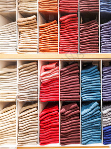 服装店的货架上摆着T恤T恤袜子连裤袜以彩虹色折叠的长筒袜粉色黑色灰色图片