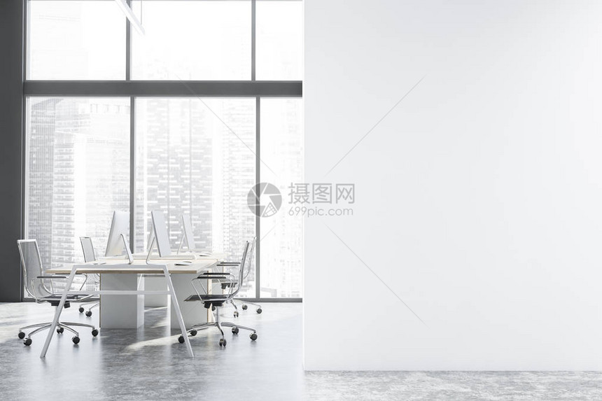 全景开放空间办公室的内部有灰色的墙壁混凝土地板带城市景观的大窗户和一排白色和木制的电脑桌图片