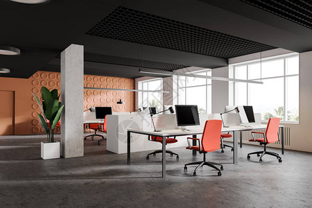 以亮橙色几何型墙壁和白计算机桌排橙色椅子3D翻接的现代开放空图片