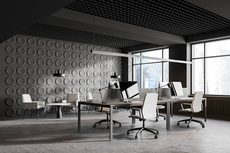 现代开放空间办公室内部有灰色几何型墙壁一排灰色计算机台和休息区图片
