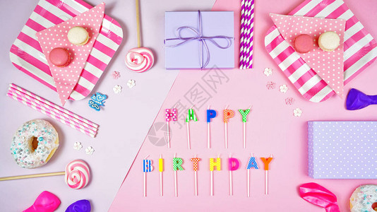 色彩缤纷的粉色主题生日派对公寓配有派对食品气球棒糖和礼物蜡烛背景图片