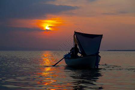剪影渔夫在船上的渔网图片