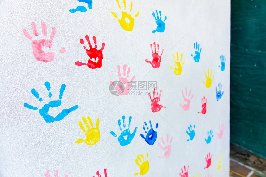 白墙背景上孤立的手彩色手印学校墙图片