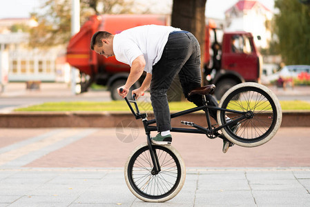 一个骑着BMX自行车的年轻人骑着前图片