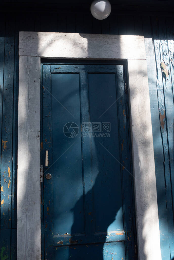 岁的蓝色画垃圾木材纹理背景古色香的蓝色木材纹理日落时在阳光下拍摄的木板老房子是他的墙一棵树上的蓝色油漆剥落图片
