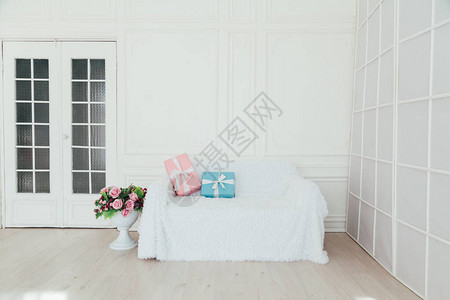 白色房间内面沙发里有蓝色和粉红色的礼物图片