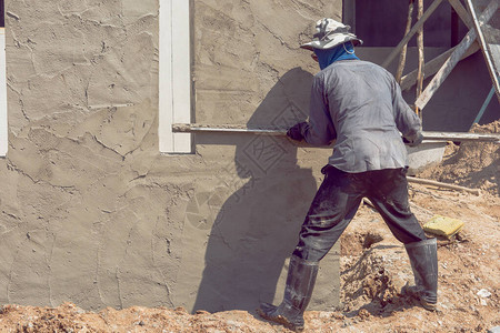 建筑工人用水泥浆粉刷建筑墙面背景图片