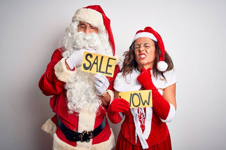 一对身穿圣诞老人服装的夫妇在孤立的白色背景上举着哇塞和销售横幅图片