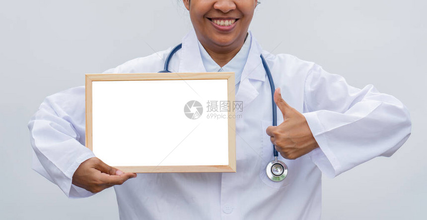 专业女医生在白色孤立的背景与白色空白板和竖起大拇指和微笑的白色外套医疗保健科学和医图片