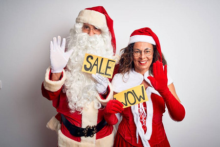 穿着圣诞老人服装的情侣在孤立的白人背景上举着华丽和销售横幅图片