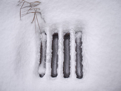 降雪后的井盖被雪覆盖雪覆盖的下水道进入金属网格图片
