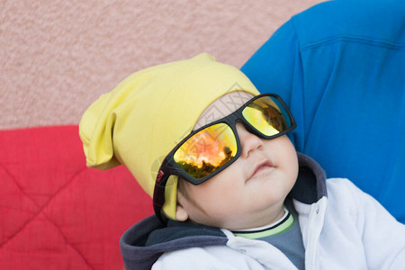 太阳镜里的孩子能保护眼睛免受太阳的照射躺在背景图片