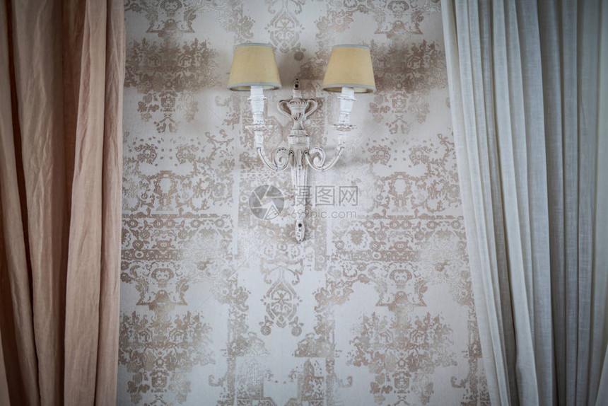 墙上的老式灯窗帘边缘有花卉图案的墙纸图片