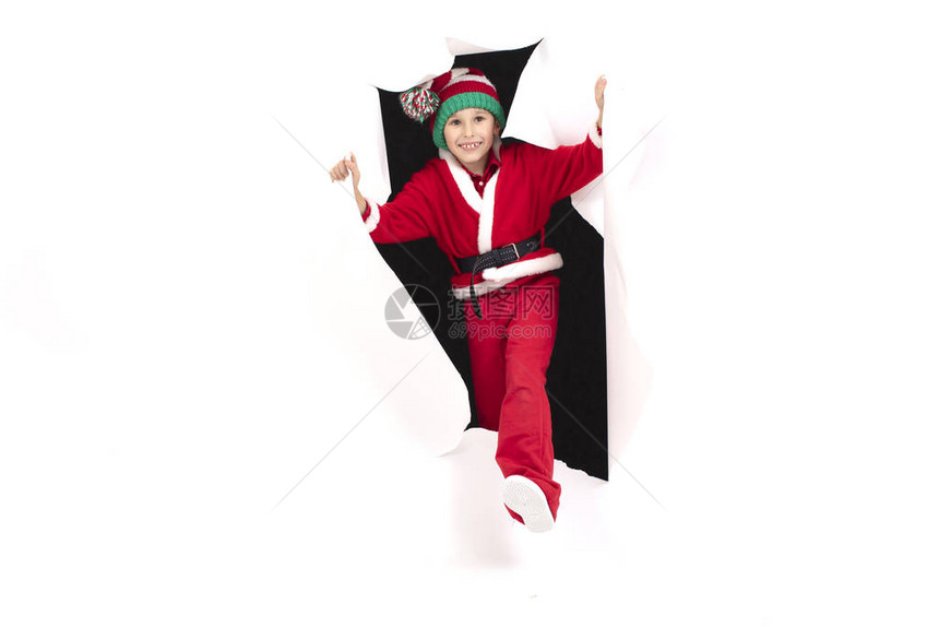儿童圣诞老人从纸上的一个洞里往外看圣诞节的男孩很高兴惊喜图片