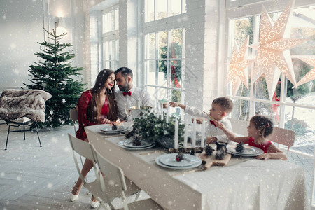 快乐的年轻一家人坐在家里的桌旁图片