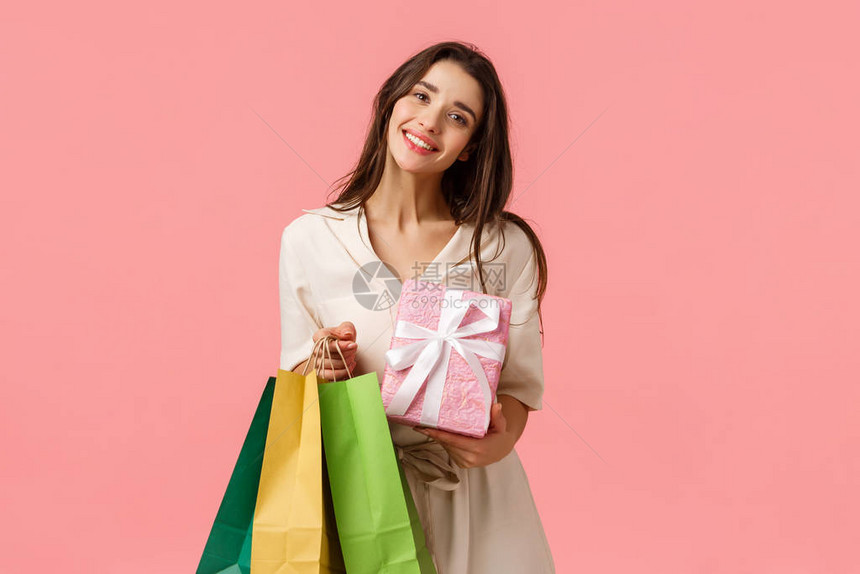 恭喜你假期和购物理念娇媚温柔的年轻女女孩从店里买了很多礼物拿着包装好的盒子站在粉红色的背景下开心图片