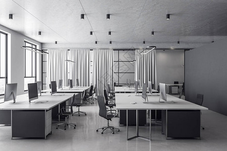 现代灰色coworking办公室内部与设备和电脑在桌面其他家具和日光背景图片
