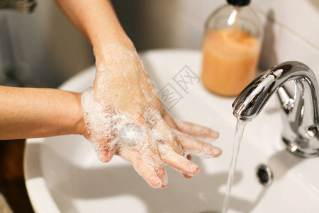 洗手在浴室流水的背景下用适当的技术和抗菌肥皂洗手摩擦手指预防冠状流图片