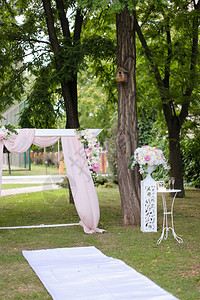 由公园的鲜花和椅子装饰的婚礼拱门图片