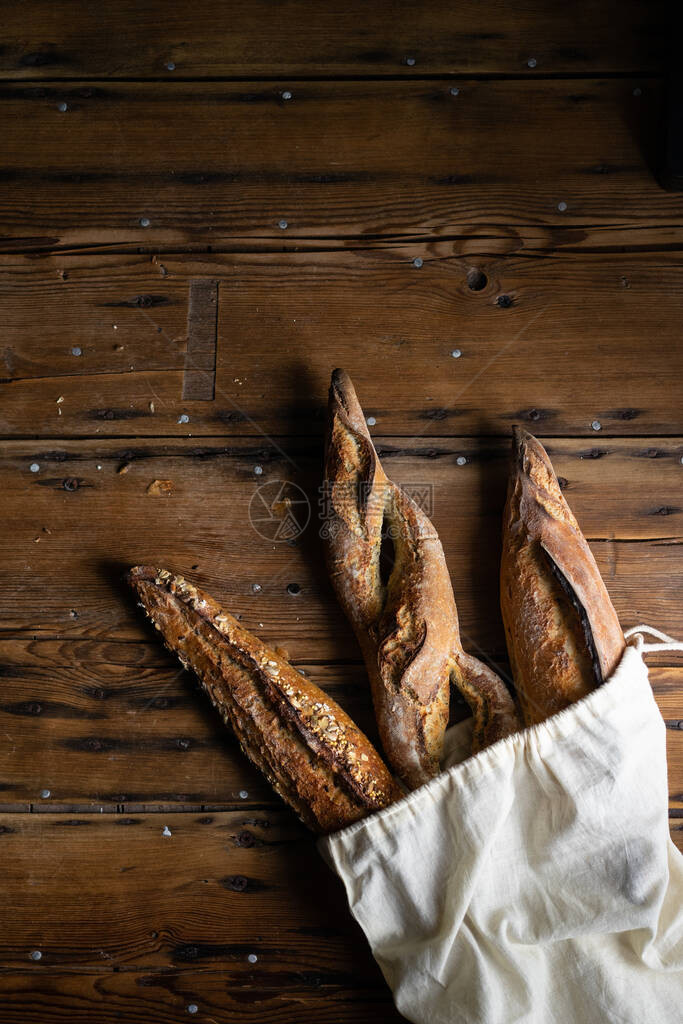 选择法国面包在木本底面包袋中挑选面包图片