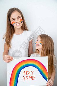 两个金发快乐的小女孩画了彩虹一张海报留在家里闪图片