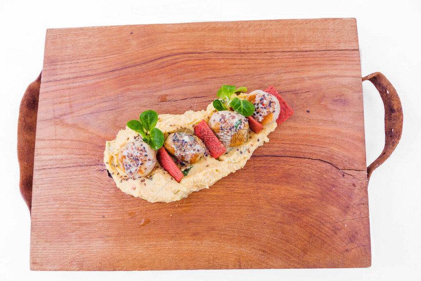盘子木板上洒满芝麻种子红面包装饰品和绿菜的小米粥肉饼或肉丸该物体在白色背景中被隔图片