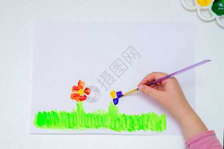 白纸上的孩子用水彩画花朵图片