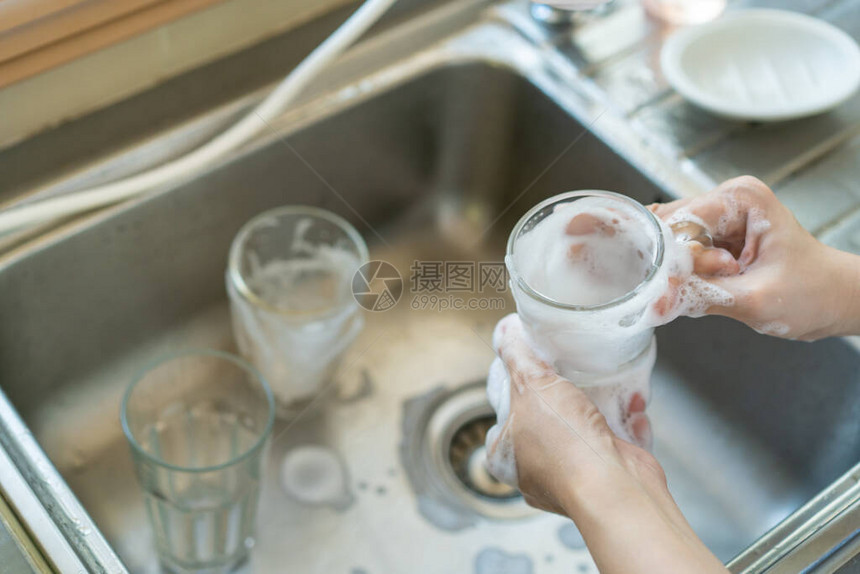 女管家在水槽里清洗用过的水杯图片