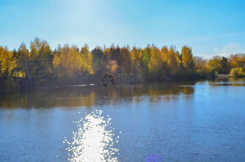 模糊的秋天风景与森林反射在湖中太阳图片