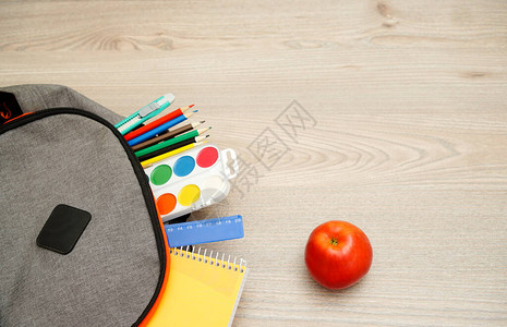 灰色背包和苹果背包里的学校用品图片