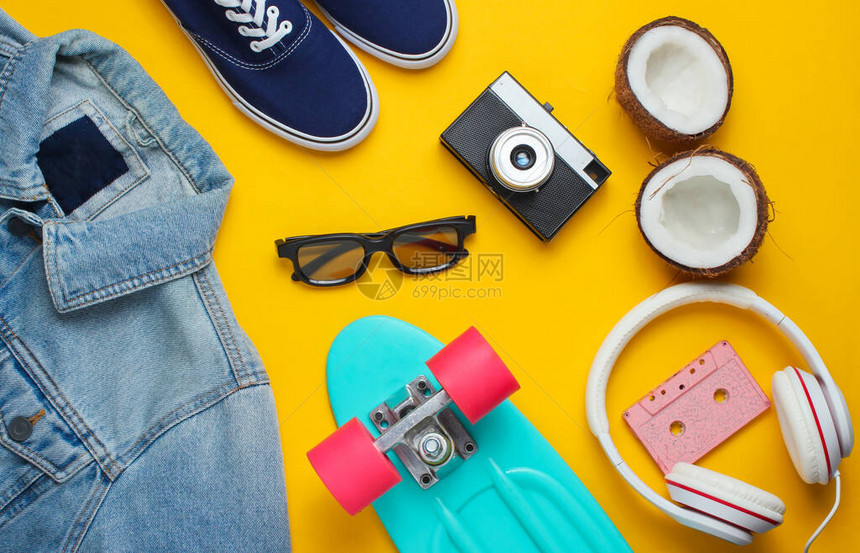 时髦的衣服黄色背景上带耳机牛仔裤夹克录音带复古相机椰子和运动鞋的滑板创意时尚极简主义最小的夏日乐趣80图片