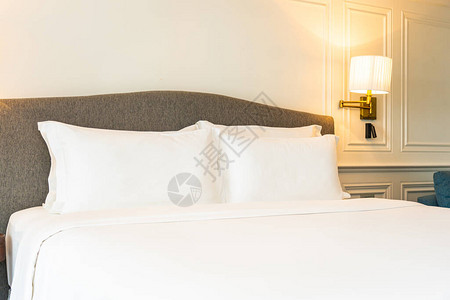 白色枕头和毯子与卧室的灯光装饰内部图片
