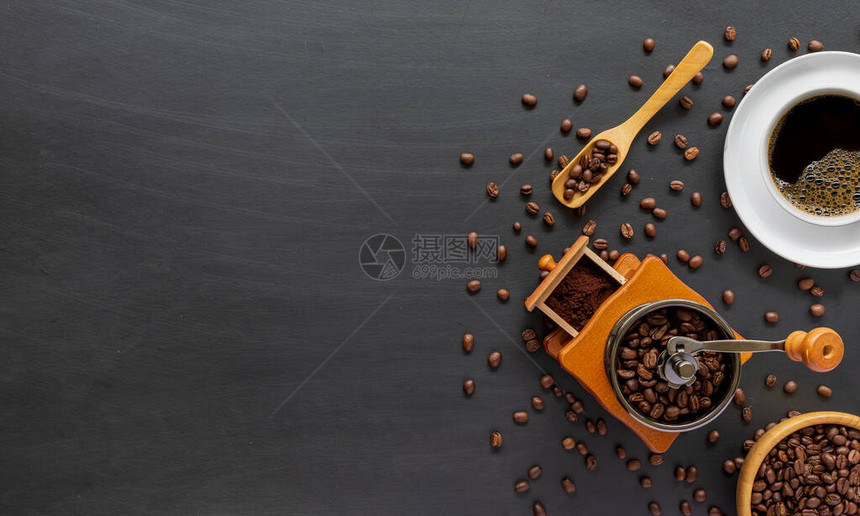 白桌背景上的热咖啡豆和手研磨图片