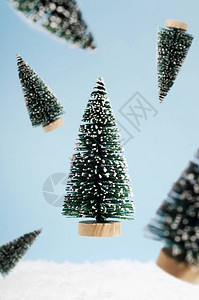 蓝色背景上的装饰塑料圣诞冷杉树的垂直背景圣诞假期创意组合与特写视图云杉冬背景图片
