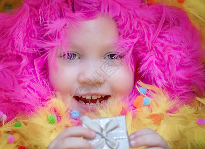 一个小女孩躺在一个模糊的节日环境里羽毛礼物生日假图片