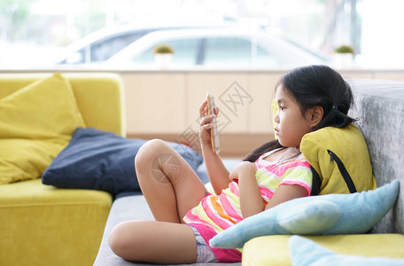 亚洲儿童可爱或小女孩坐在沙发上背景图片